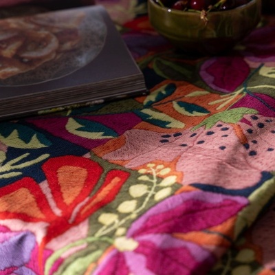 Toalha de mesa com padrão floral colorido e objetos em cima