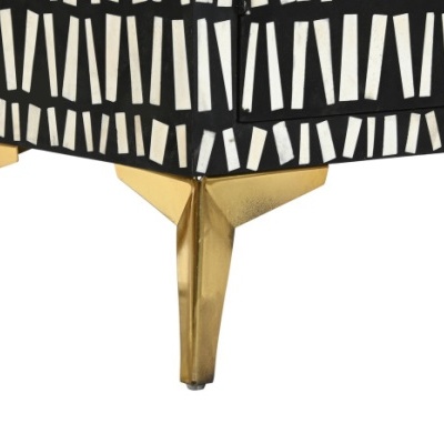 Pernas douradas de móvel com tecido preto e branco padrão geométrico