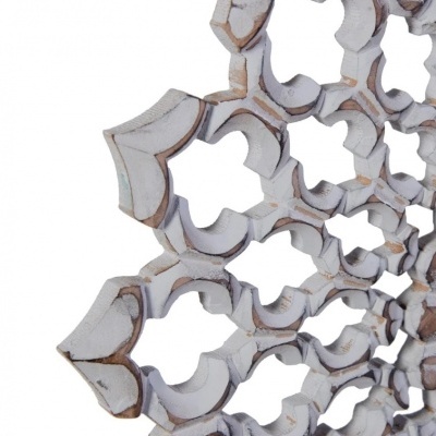 Detalhe de peça decorativa de madeira com padrão geométrico branco desgastado