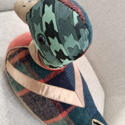 Pato decorativo em tecidos coloridos com padrões pied-de-poule e xadrez