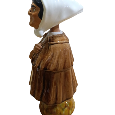 Estatueta em cerâmica de figura feminina com lenço branco e capa castanha