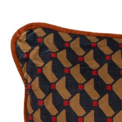 Almofada decorativa azul com padrão geométrico castanho e vermelho e bordas castanho alaranjadas