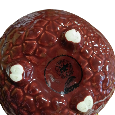 Base de vaso cerâmico castanho com três pés em forma de coração branco e carimbo preto circular