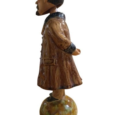 Estátua decorativa de homem com casaco castanho e chapéu preto, vista lateral