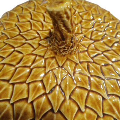 Pote de cerâmica castanho com padrão texturizado de folhas e puxador em forma de tronco