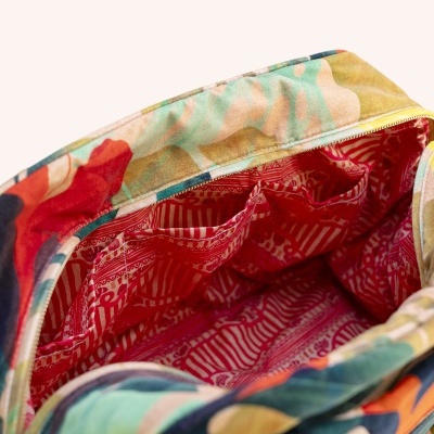 Mala com padrão floral colorido e interior vermelho com padrão geométrico branco