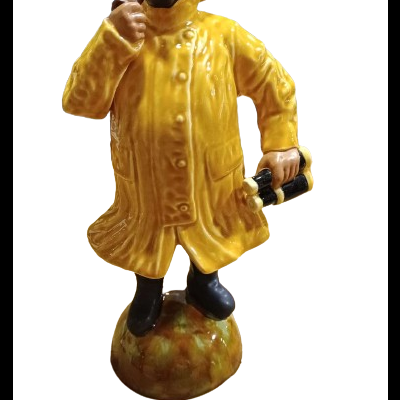 Estatueta de homem com casaco impermeável amarelo e binóculos