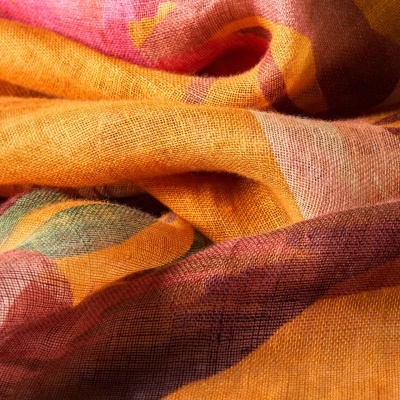 Tecido leve com padrão colorido e textura rugosa em tons de laranja e rosa