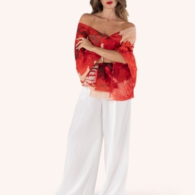 Mulher com lenço ou xale vermelho com padrão abstracto e calças largas brancas