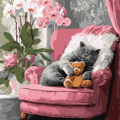 Gato cinza a dormir numa poltrona rosa com urso de peluche e flores ao lado