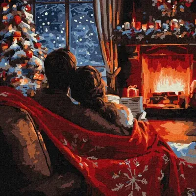 Casal sentado no sofá com manta vermelha junto a lareira acesa e decoração de Natal