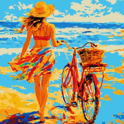 Mulher com chapéu amarelo e saia colorida na praia com bicicleta vermelha e cesto de vime