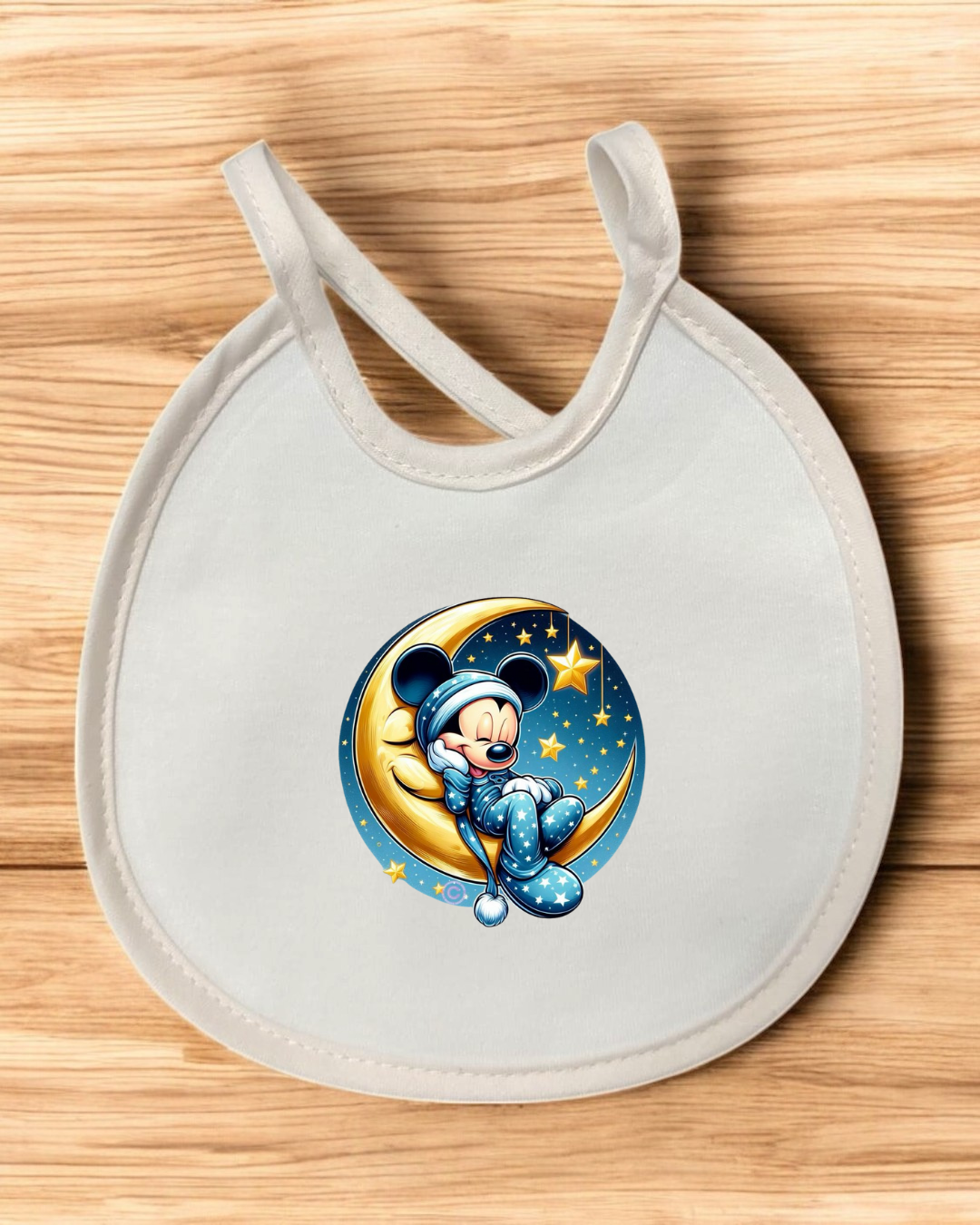 Babete branco com desenho do Mickey Mouse sentado numa lua e estrelas