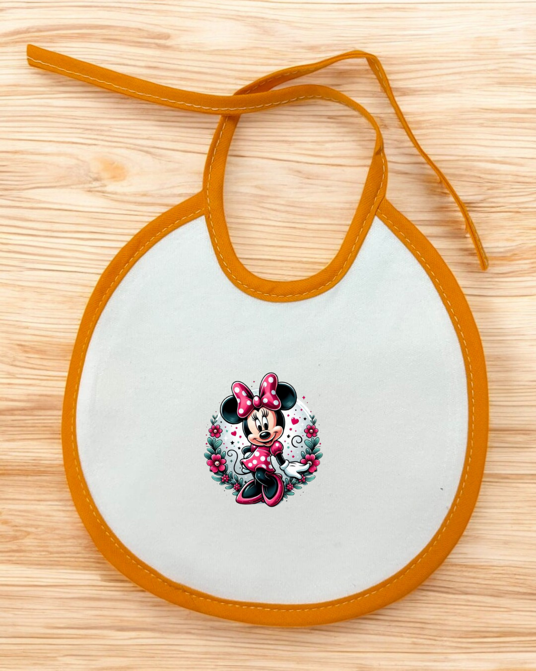 Babete branco com borda laranja e imagem da Minnie Mouse