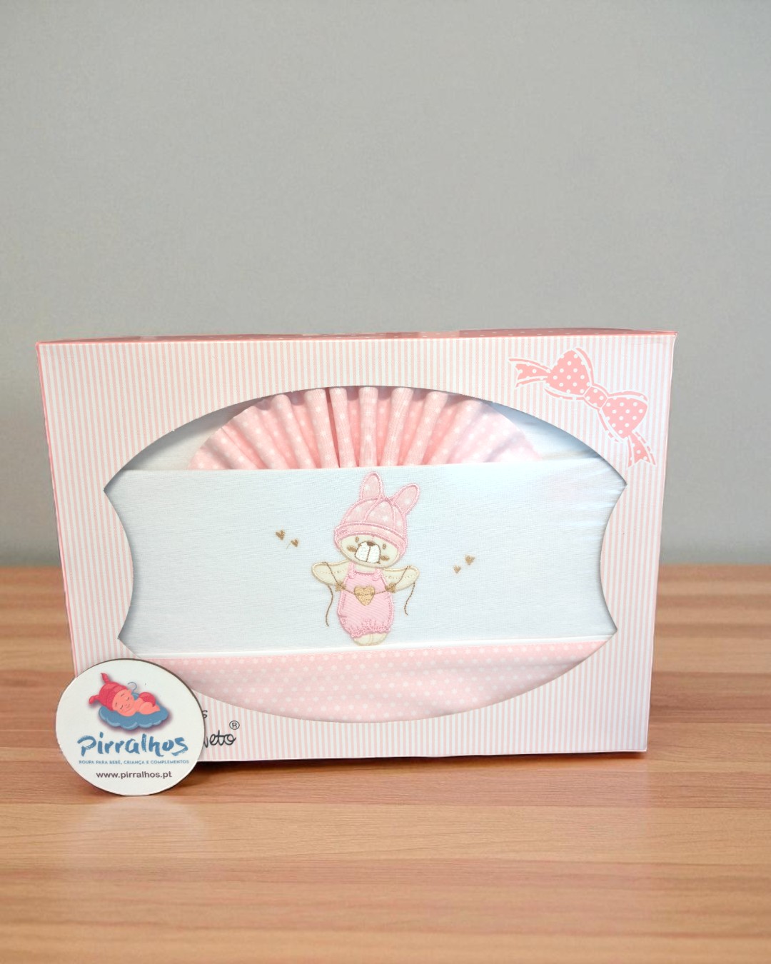 Conjunto de roupa de bebé rosa e branco com ursinho bordado na embalagem