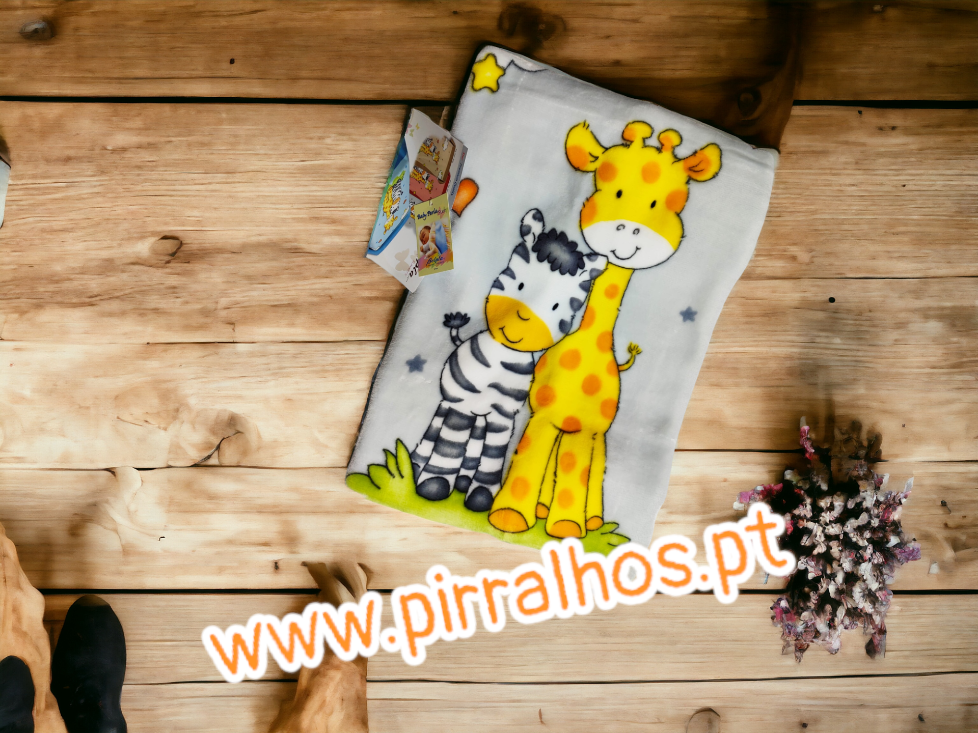 Fralda ou toalha infantil com desenhos de girafa e zebra sobre madeira clara