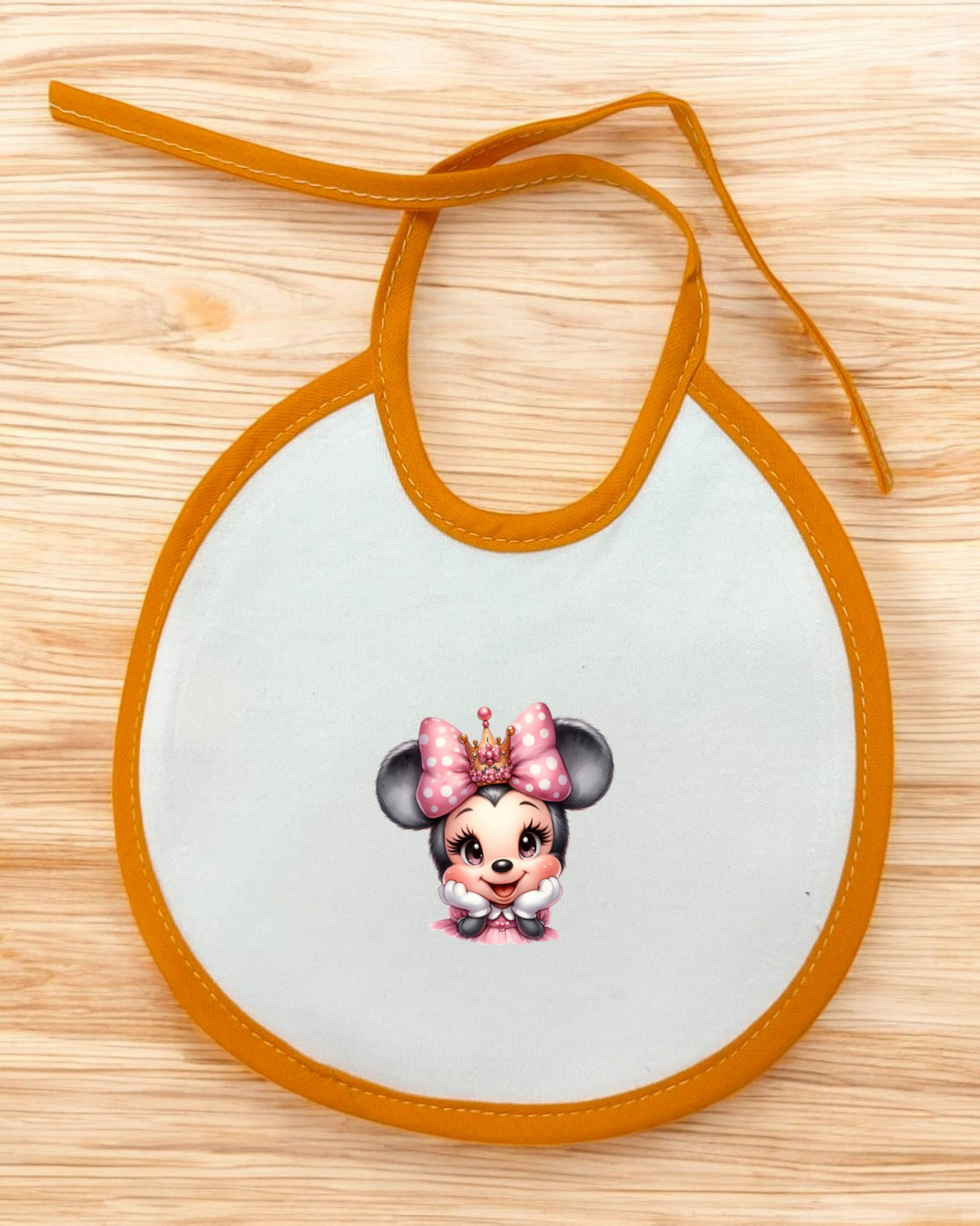 Babete para bebé branco com contorno laranja e personagem cartoon com laço rosa
