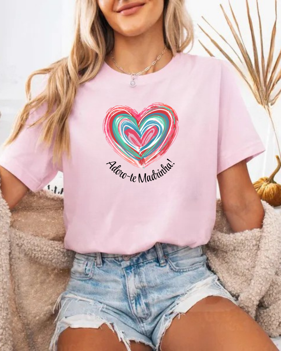 T-shirt rosa clara com coração colorido e texto 'Adoro-te Madrinha!' usada com jeans rasgados
