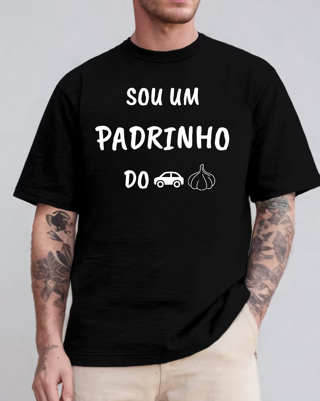 T-shirt preta com texto em branco e ícones de carro e alho usada por pessoa tatuada