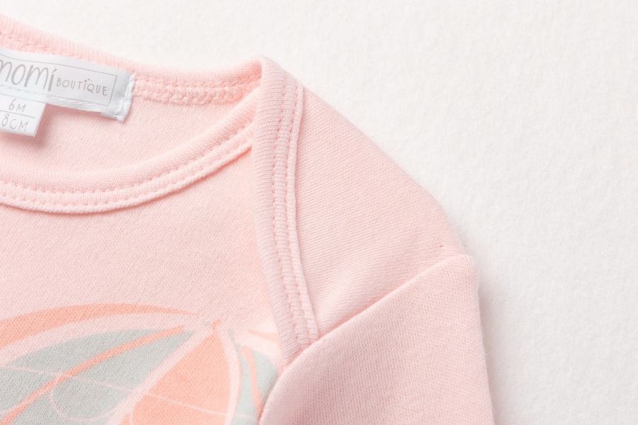 Body rosa para bebé com estampa colorida e etiqueta interna visível