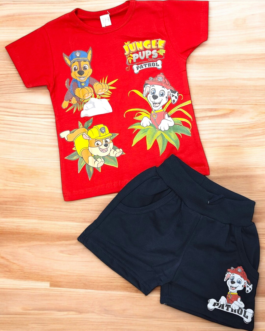 Conjunto infantil com t-shirt vermelha com personagens da série Jungle Pups Patrol e calções pretos com personagem estampado