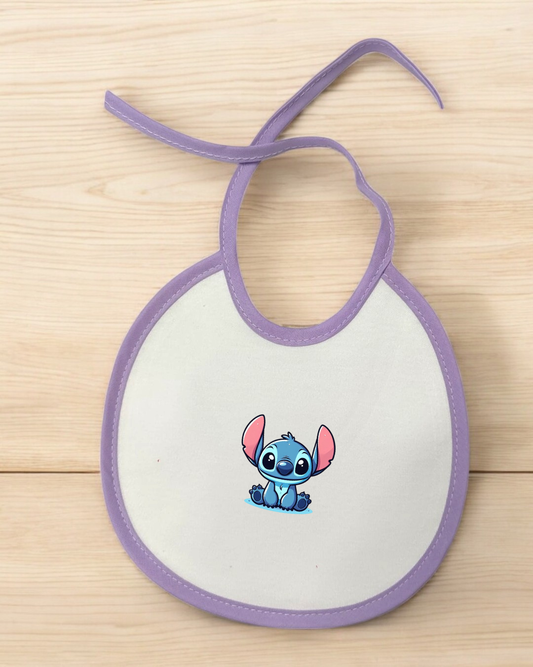 Babete branco com contorno lilás e ilustração do Stitch ao centro