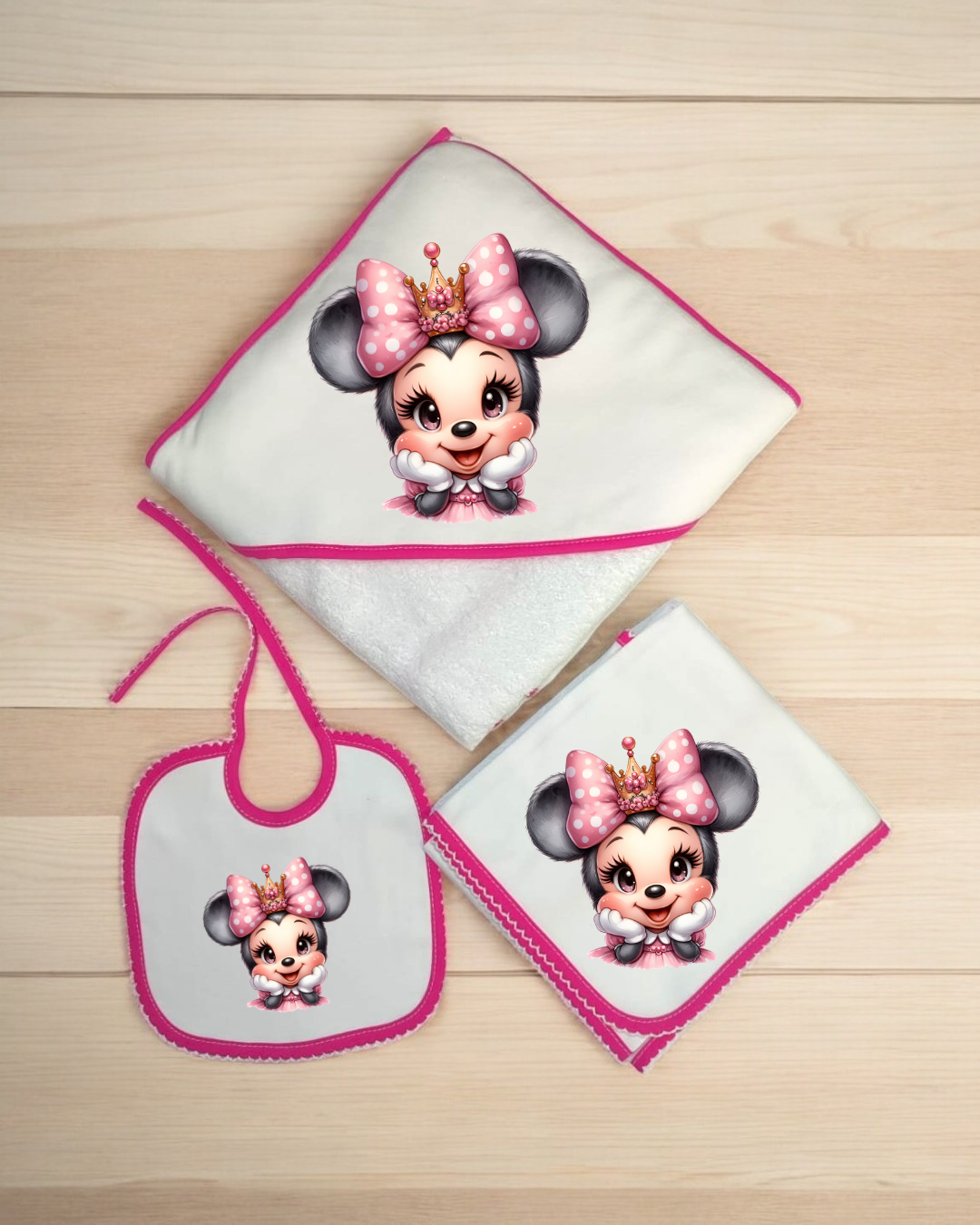 Conjunto de toalha, babete e fralda branca com bordas rosa e estampa Minnie Mouse cor-de-rosa.