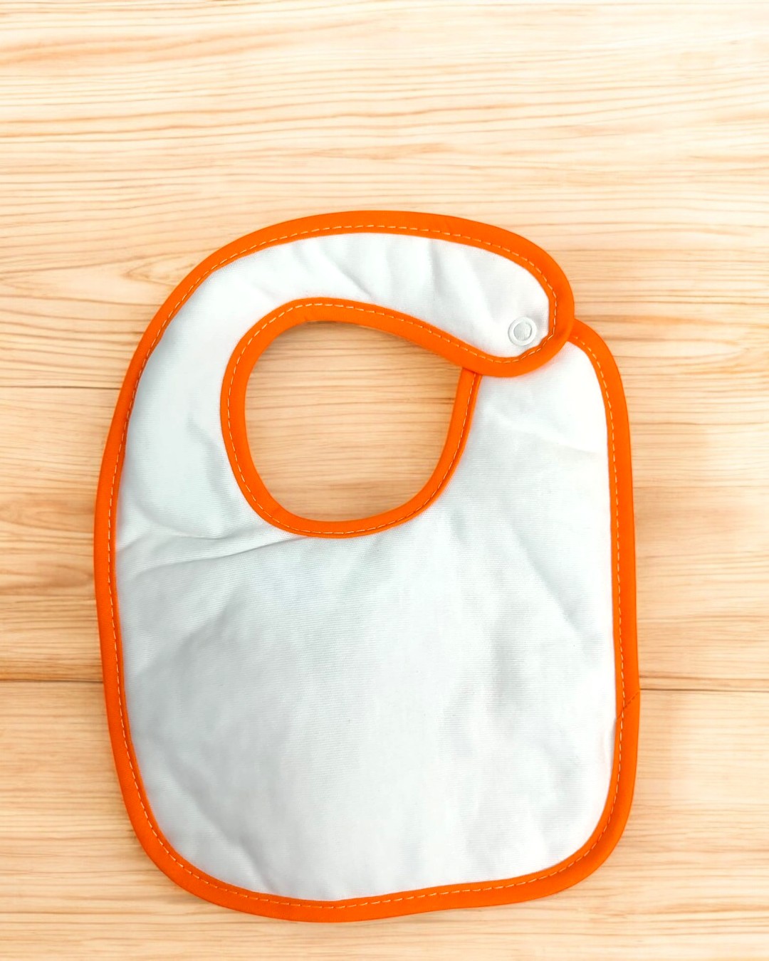 Babete para bebé branco com bordas laranja