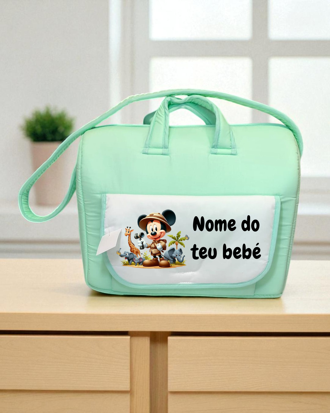 Mala de bebé verde água com bolso branco e imagem do Mickey com texto em português