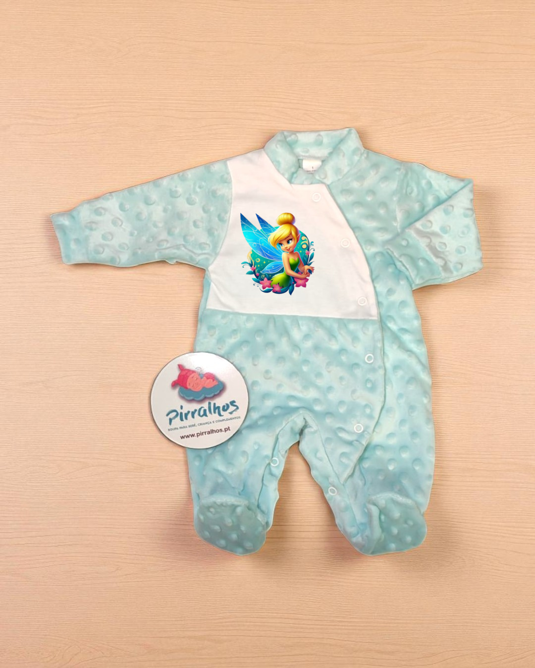 Macacão de bebé azul claro com estampa da fada Sininho e etiqueta da marca Pirralhos.