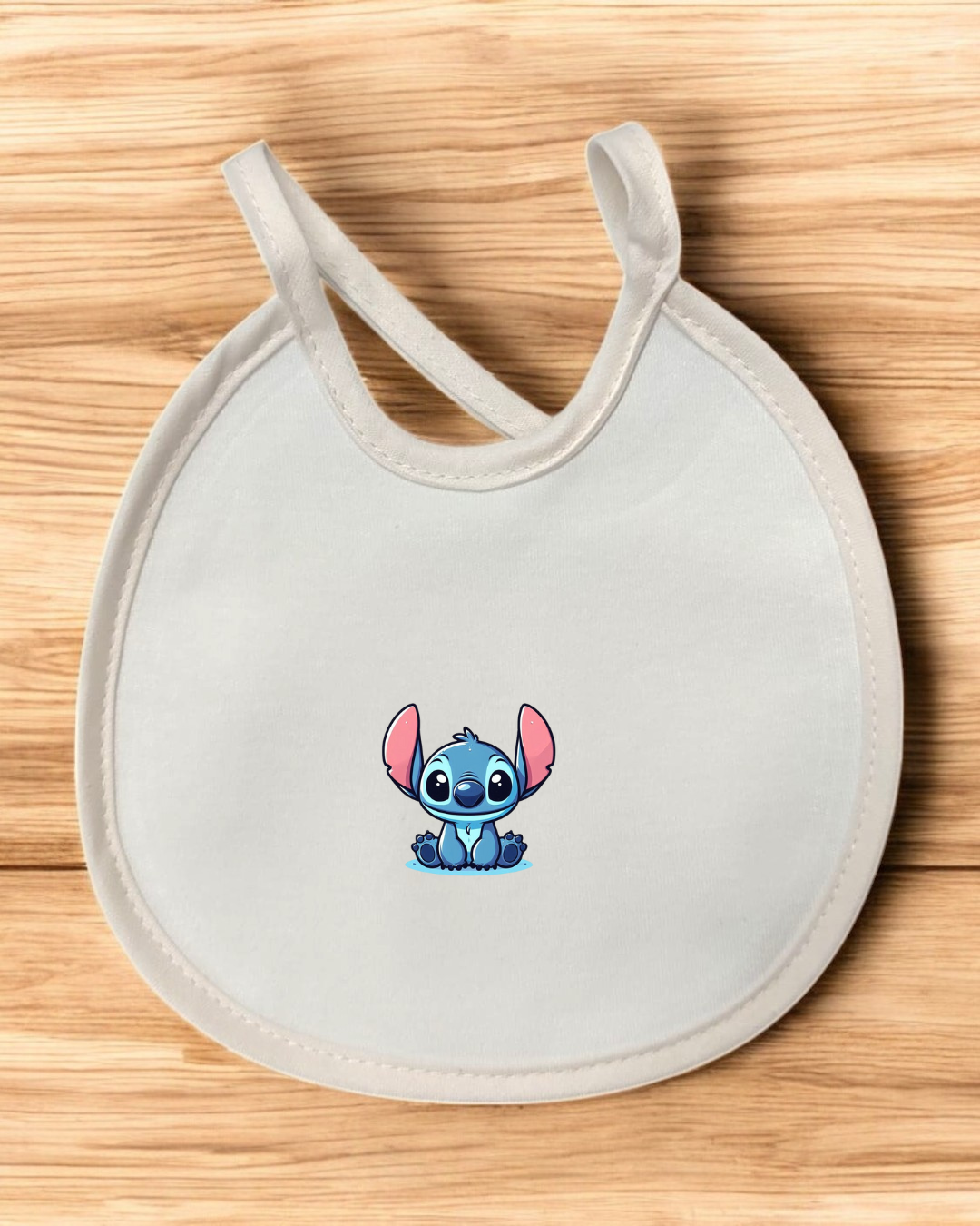 Babete branco com bordas bege e ilustração do personagem Stitch