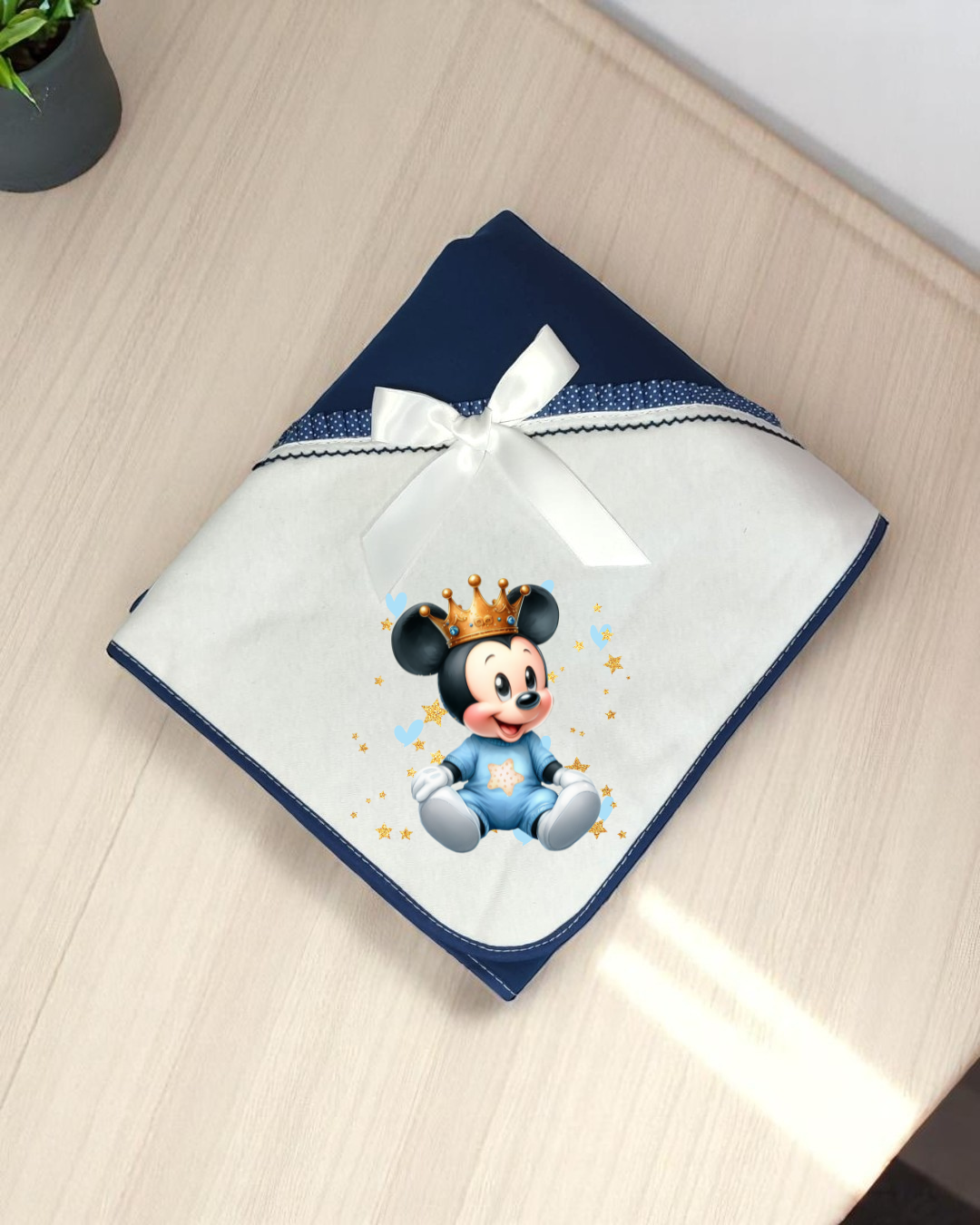 Manta de bebé azul e branca com laço e imagem de Mickey bebé com coroa