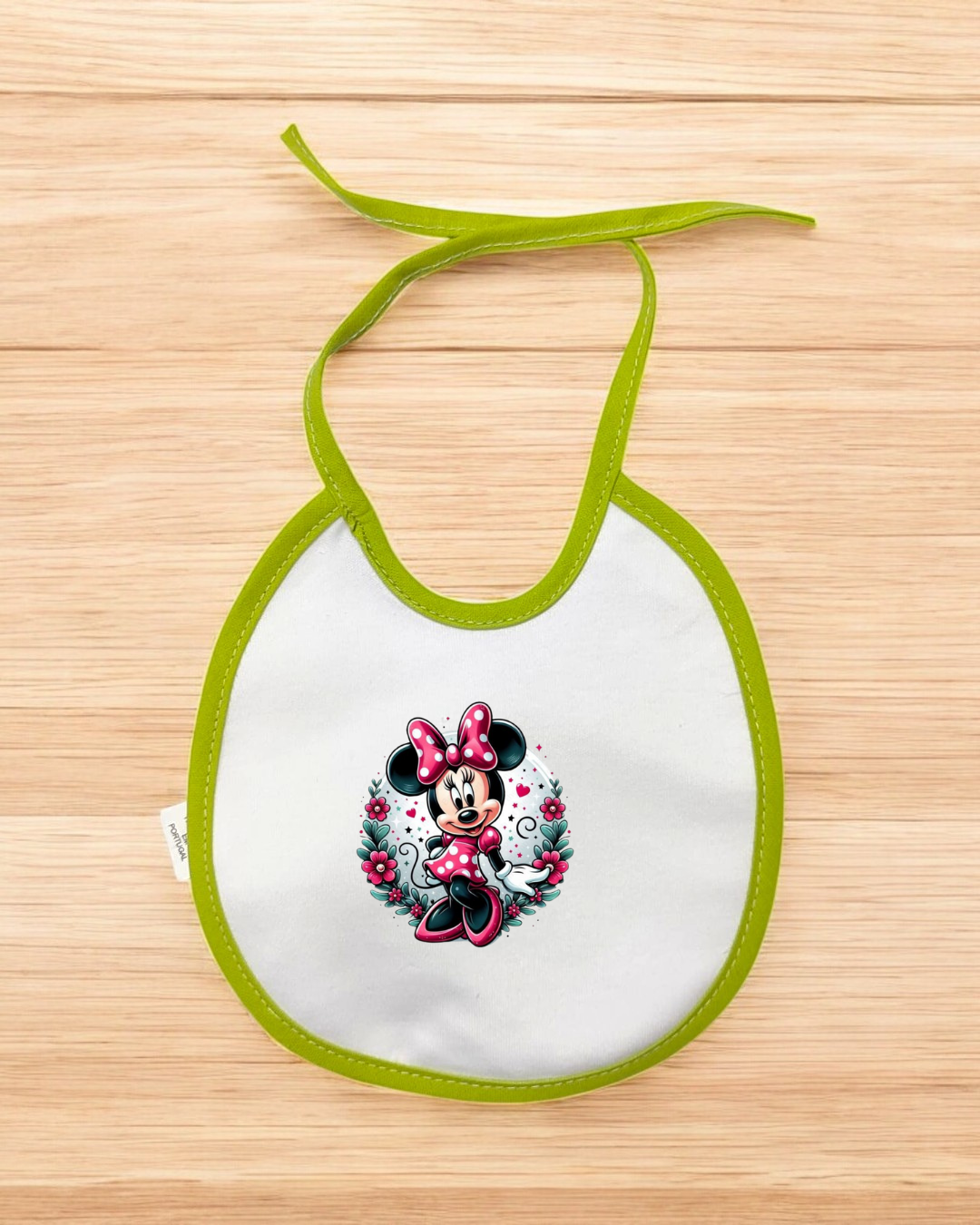 Babete branco com borda verde e estampado da Minnie Mouse em vestido rosa.