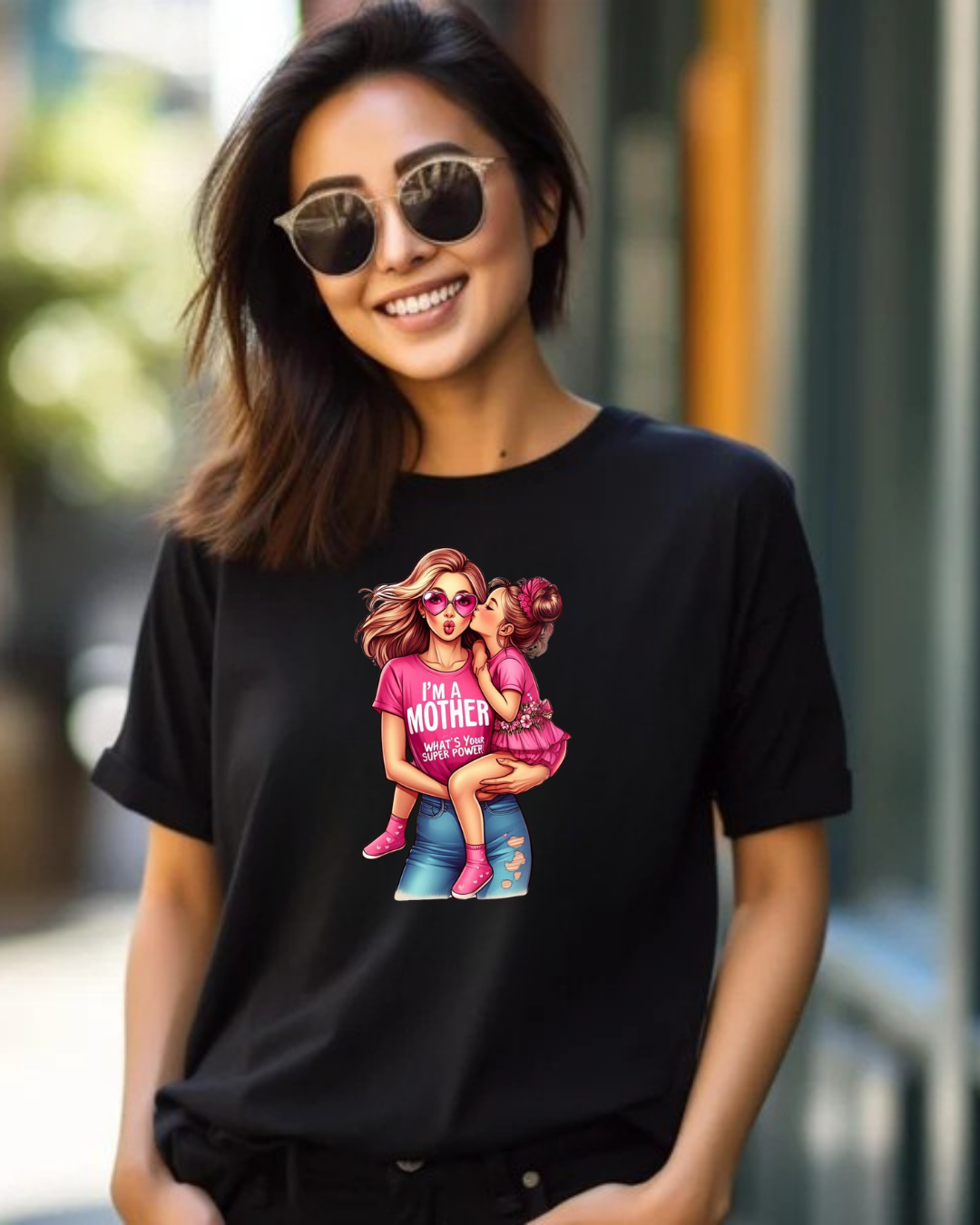 Mulher com t-shirt preta estampada com desenho colorido de mãe e filha e texto em inglês, usando óculos escuros
