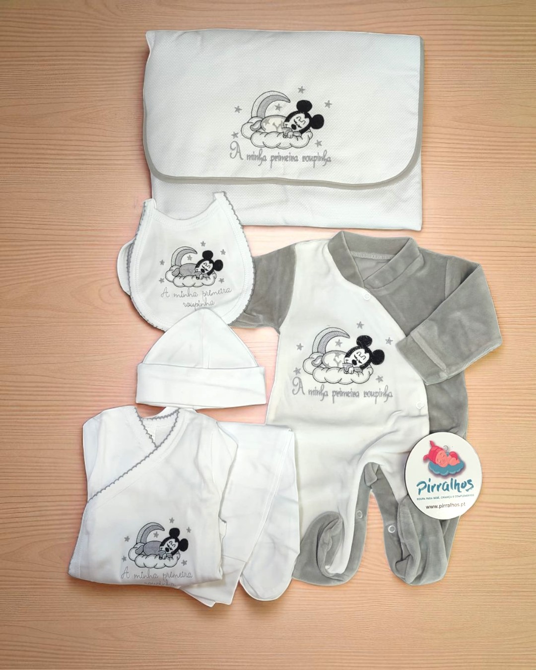 Conjunto de roupa de bebé branco e cinzento com Mickey Mouse a dormir na lua e texto A minha primeira roupinha