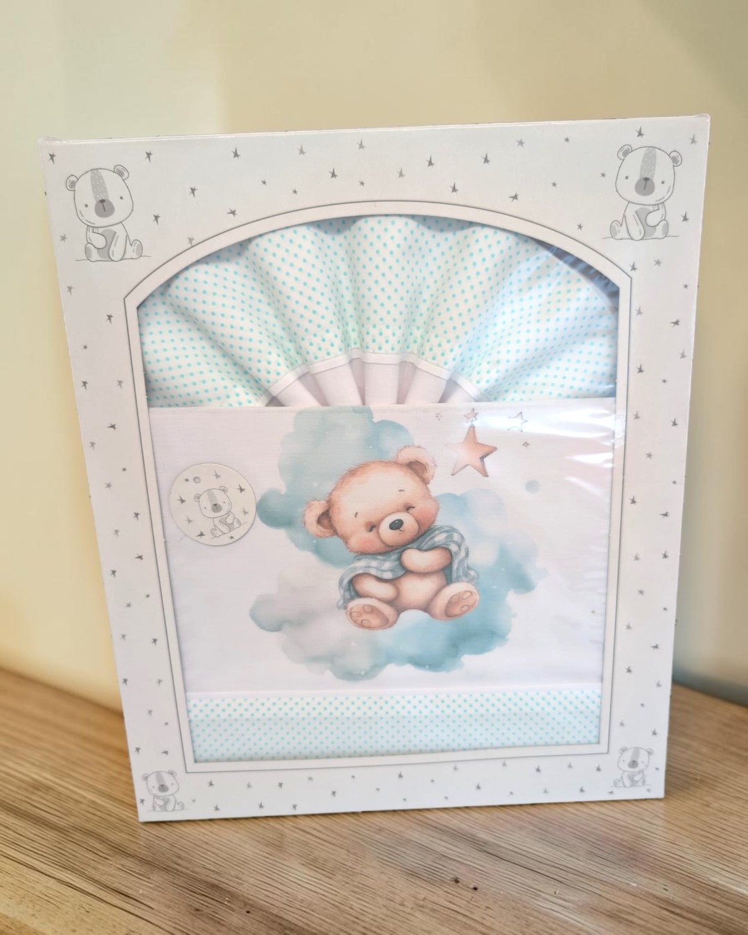 Jogo de cama de bebé com padrão de bolinhas azuis e ilustração de urso bebé numa nuvem