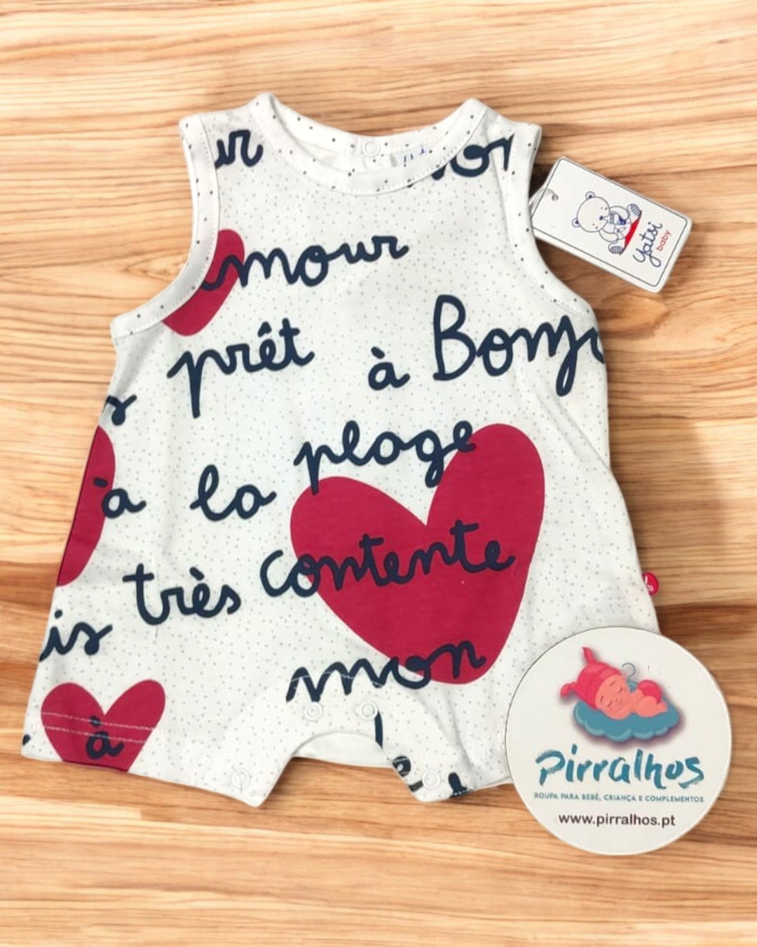 Macacão bebé branco com corações vermelhos e texto manuscrito em francês.