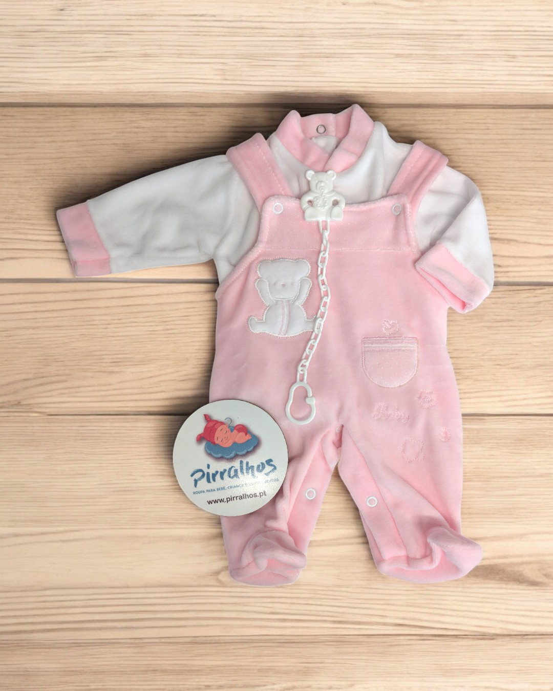 Conjunto de roupa de bebé com camisola branca e detalhes rosa, macacão rosa em veludo com ursinho bordado e prendedor para chucha