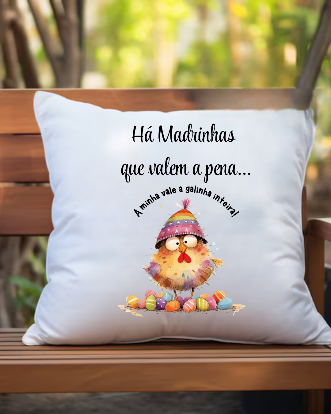 Almofada branca com estampa de galinha colorida e texto em português colocada num banco de madeira