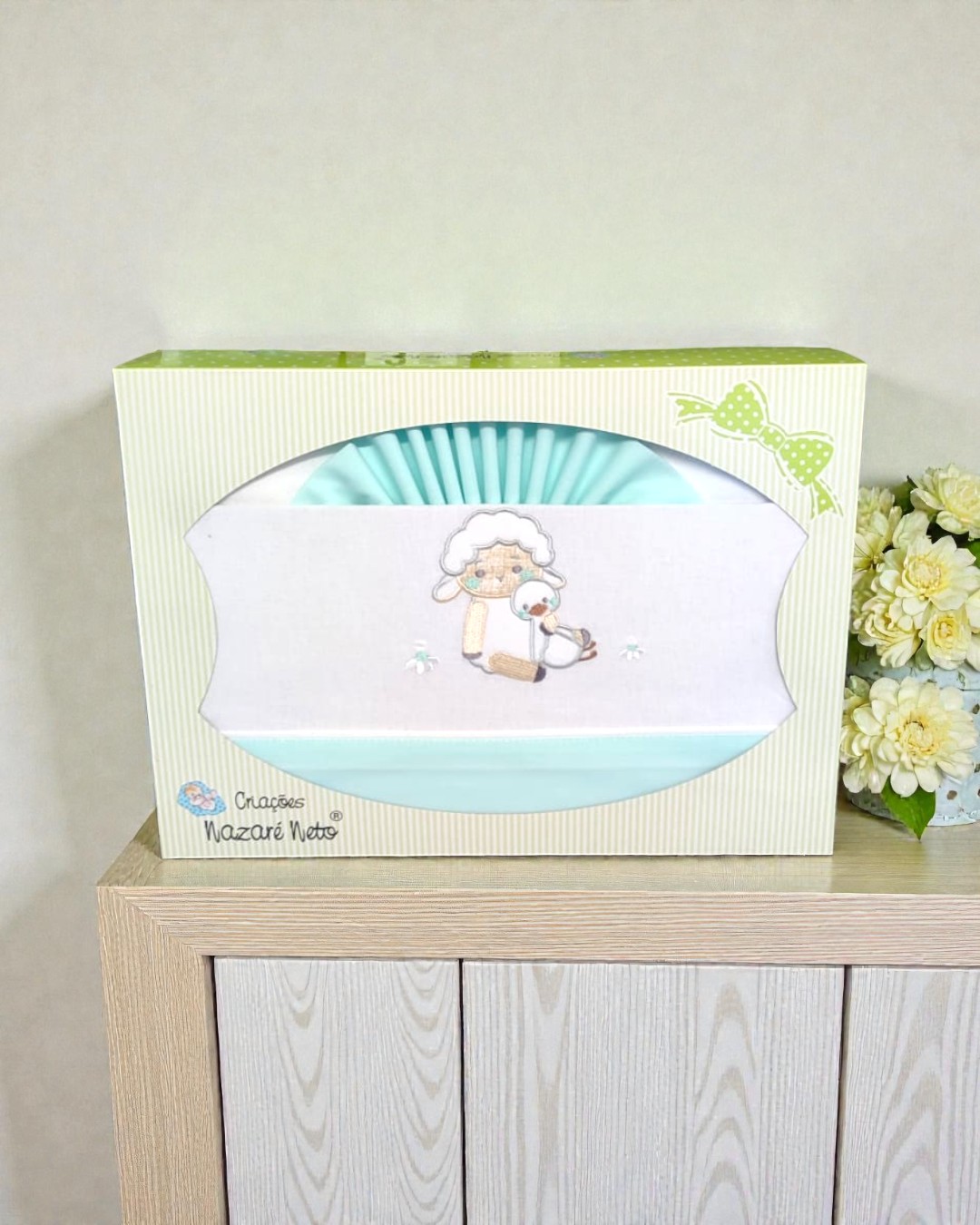 Jogo de cama para bebé azul com bordado em embalagem creme com riscas e fita verde