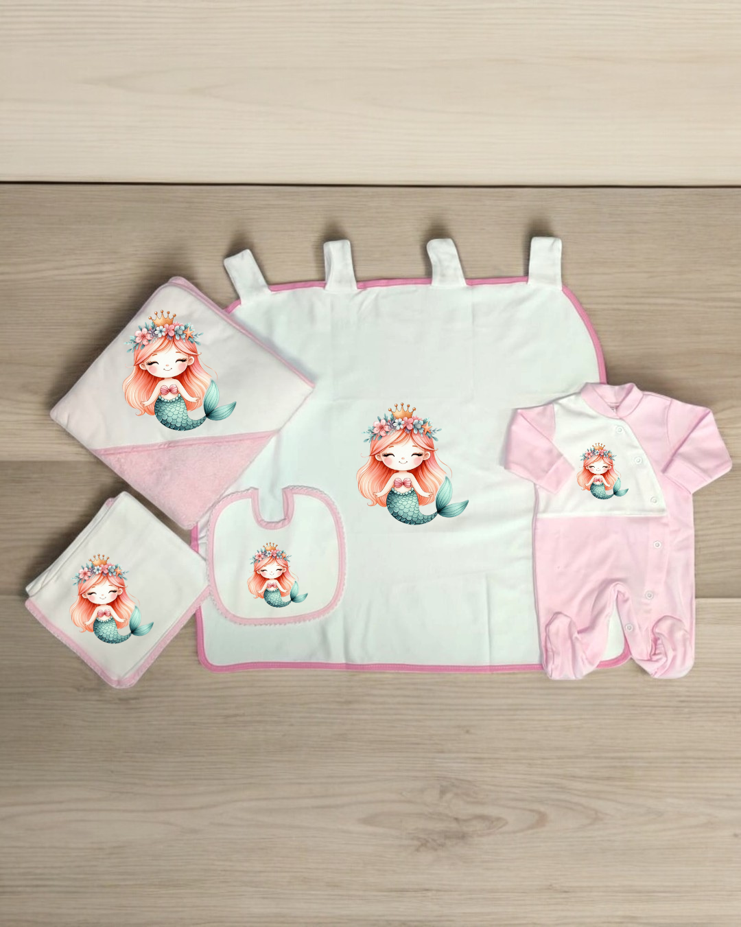 Conjunto bebé com babete, manta, toalha e pijama com estampa de sereia cor-de-rosa