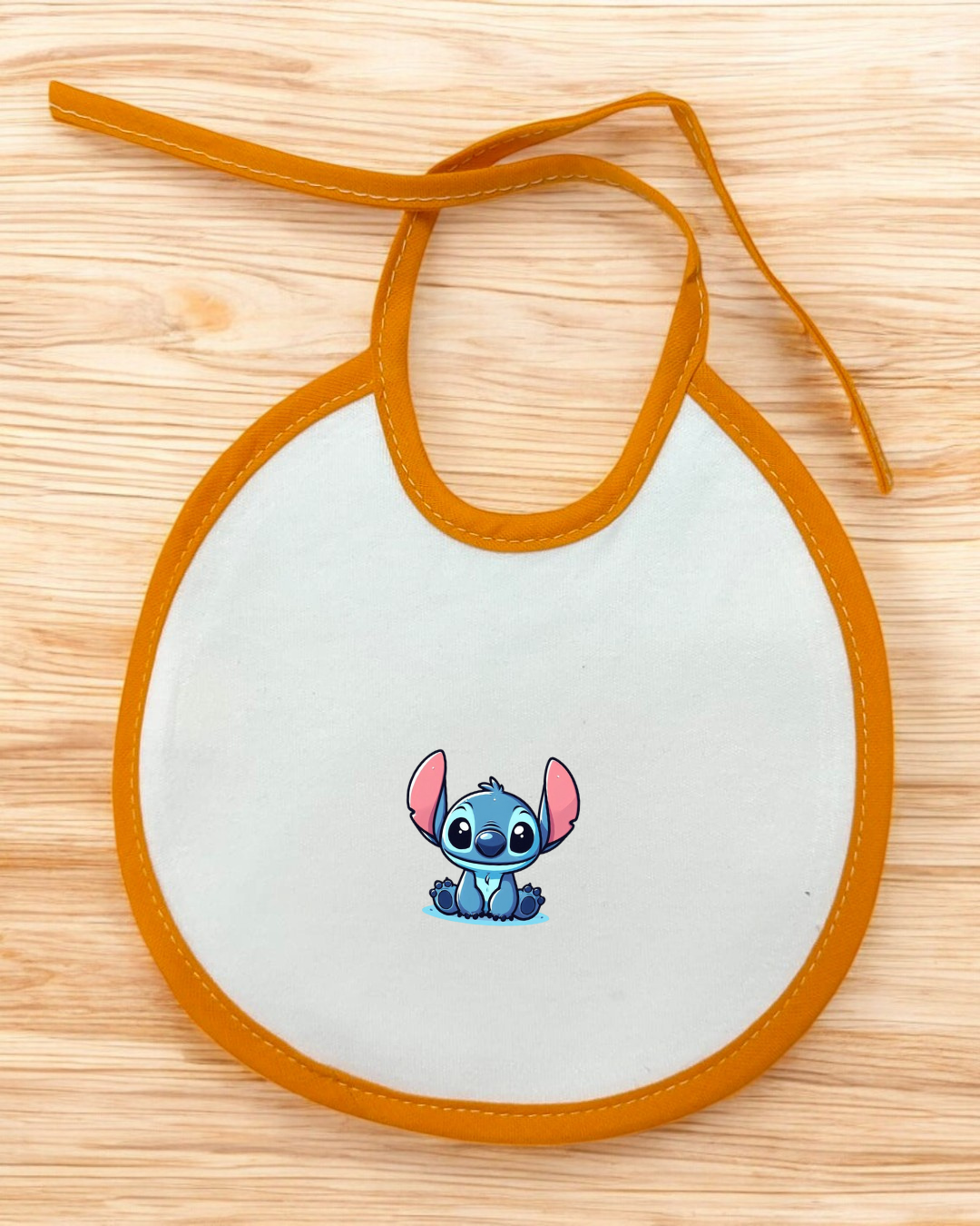 Babete branco com borda laranja e estampa do personagem Stitch