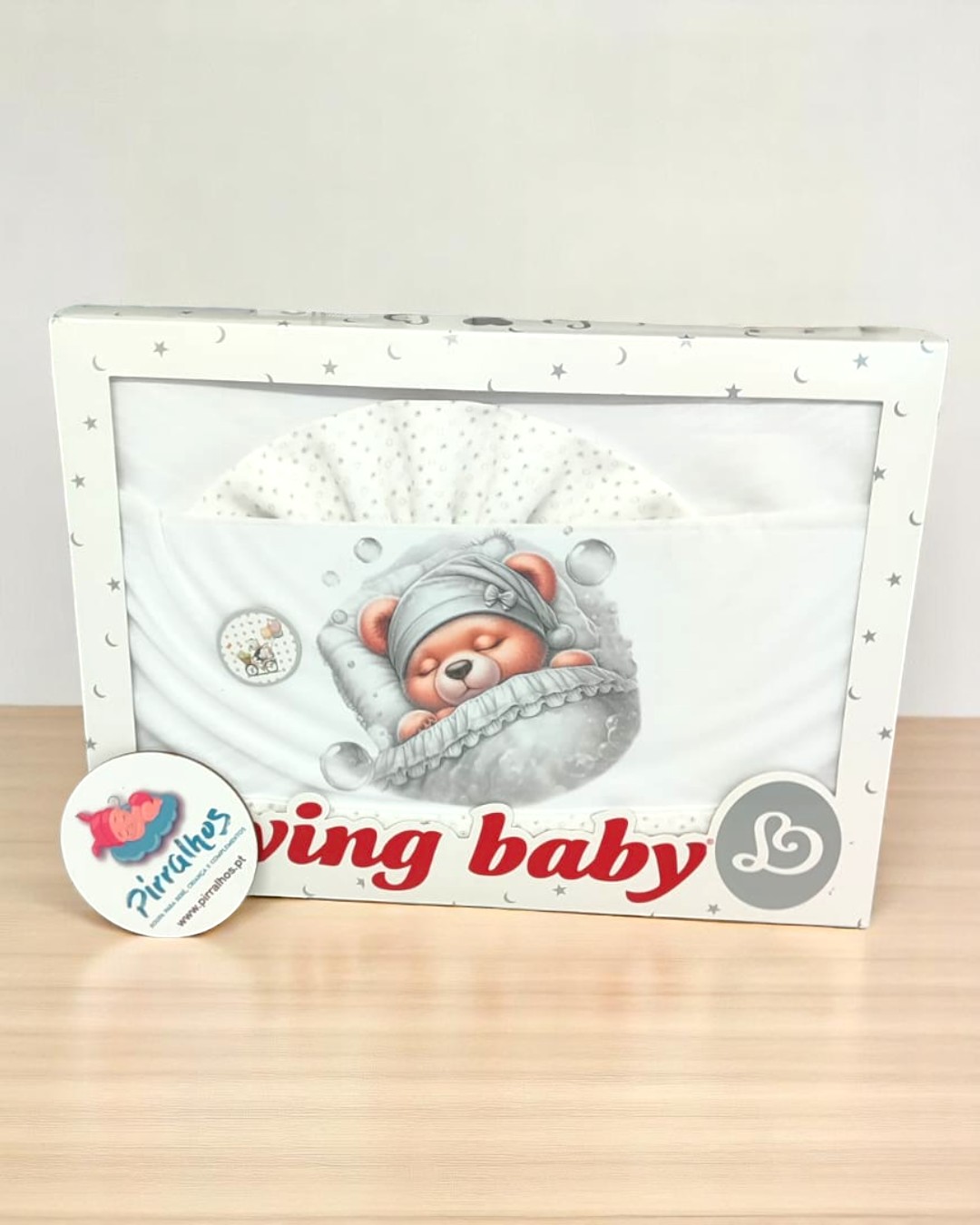 Conjunto para bebé com manta branca estampada numa caixa com imagem de urso e texto