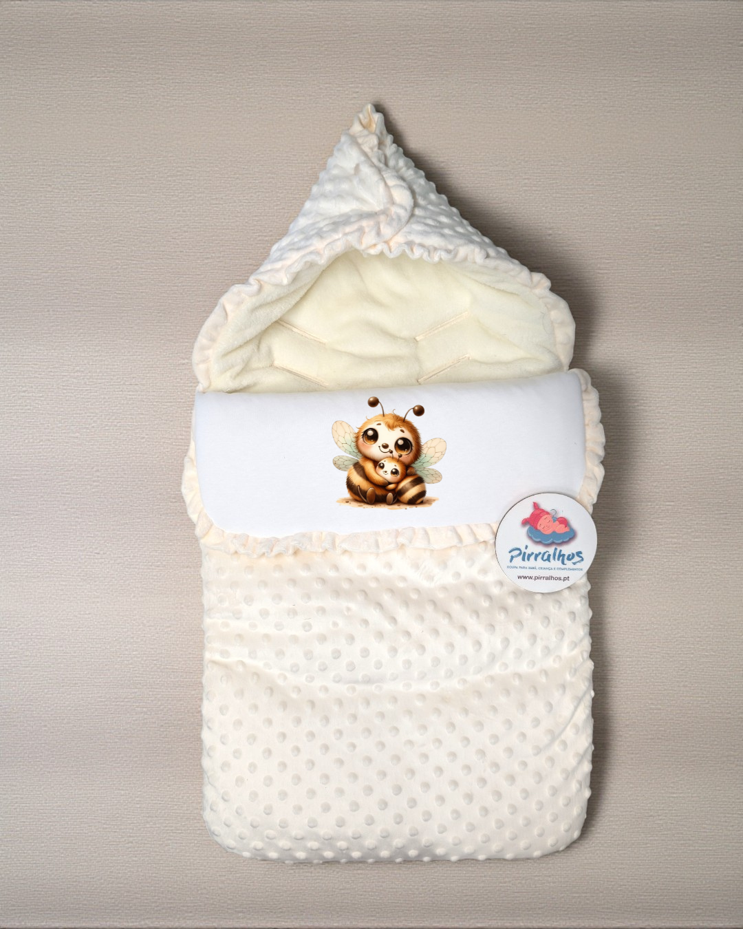 Saco de bebé branco com padrão de pontos e desenho de abelhas.