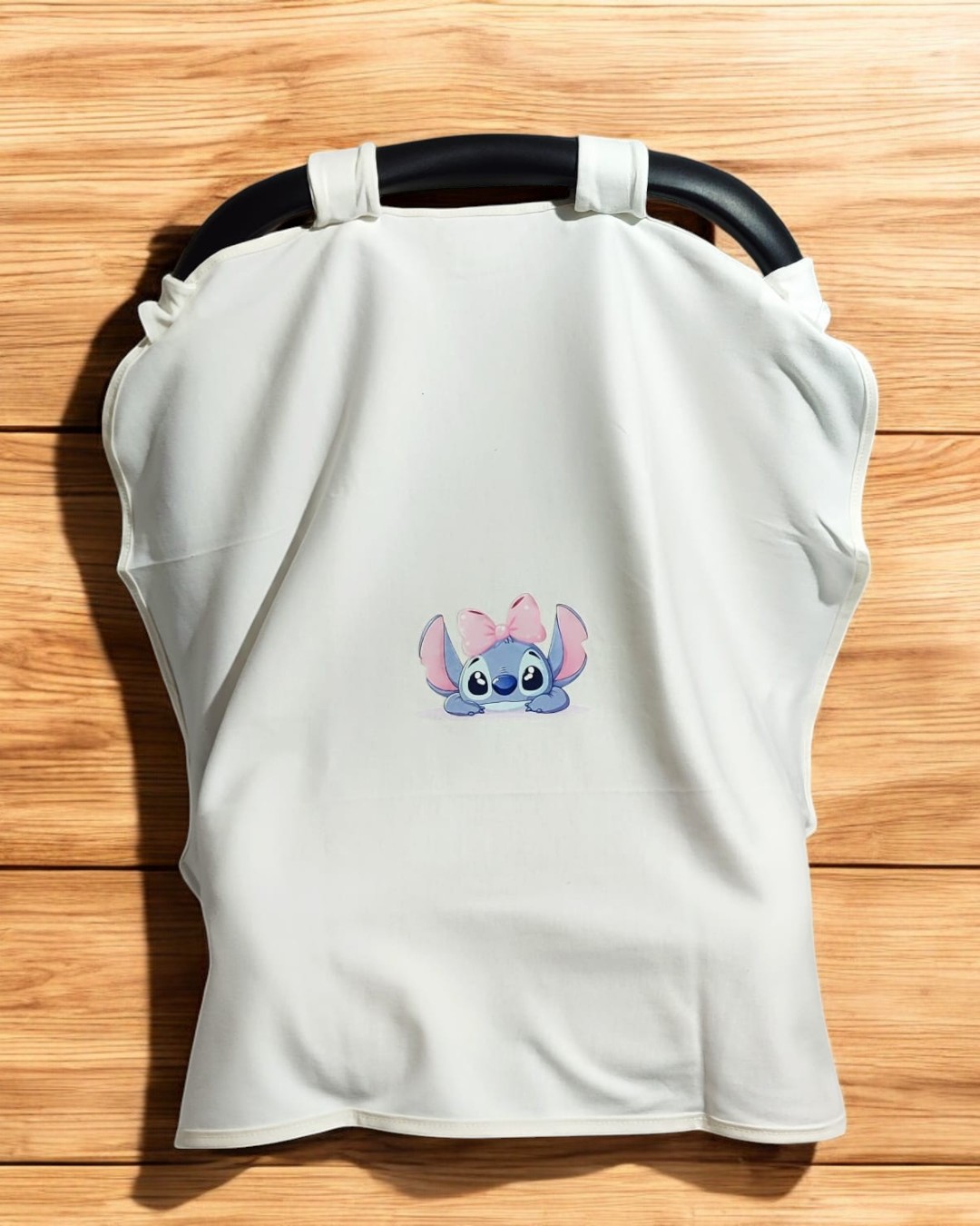 Capa branca para carrinho de bebé com ilustração de personagem azul com laço cor-de-rosa