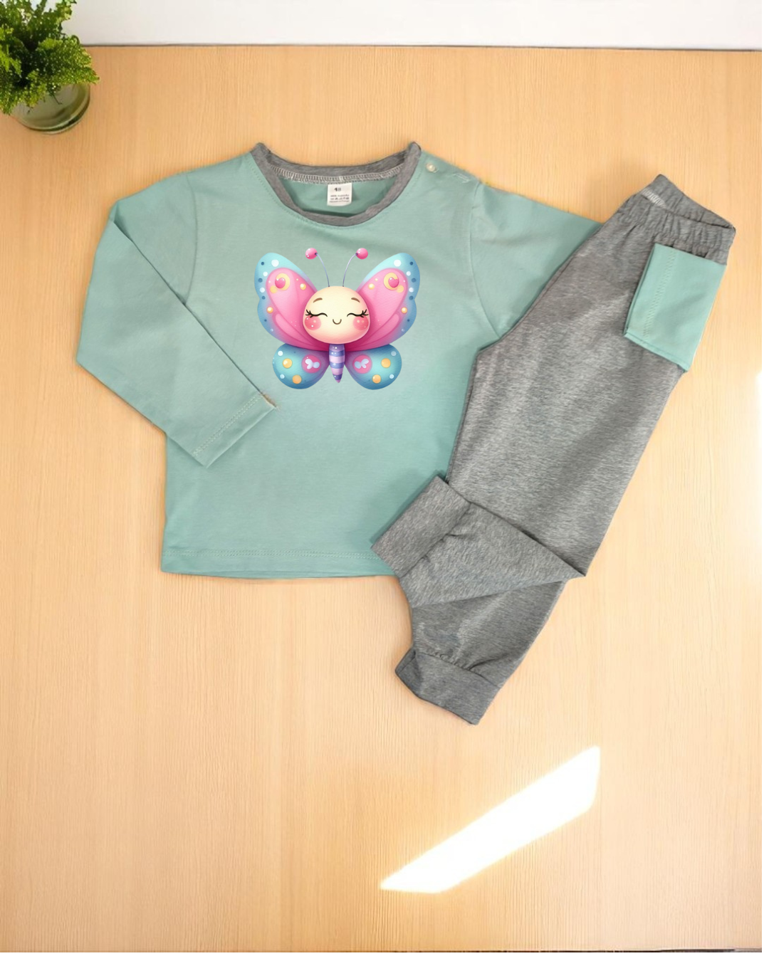 Conjunto de pijama infantil com camisola verde-água estampada e calças cinzentas com bolso
