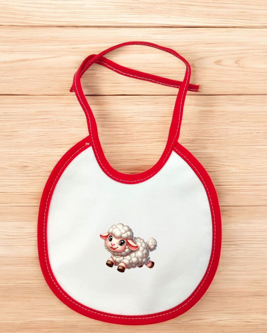 Babete branco com borde vermelho e ilustração de cordeiro no centro