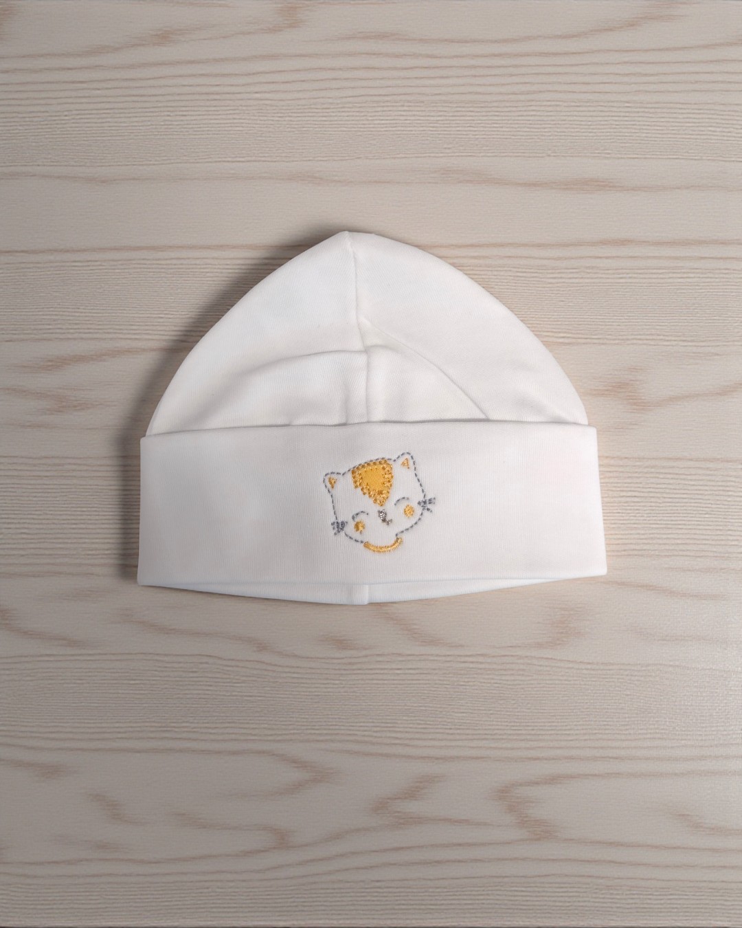 Gorro branco de bebé com bordado de rosto de gato amarelo
