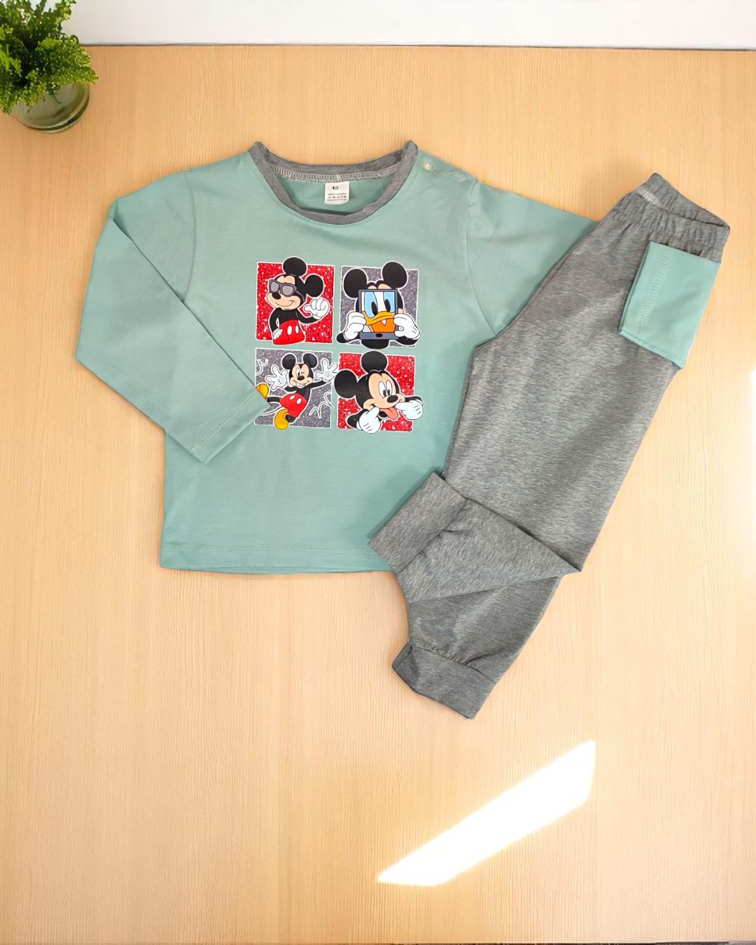 Conjunto de roupa infantil verde-água e cinzenta com estampados de Mickey e Donald