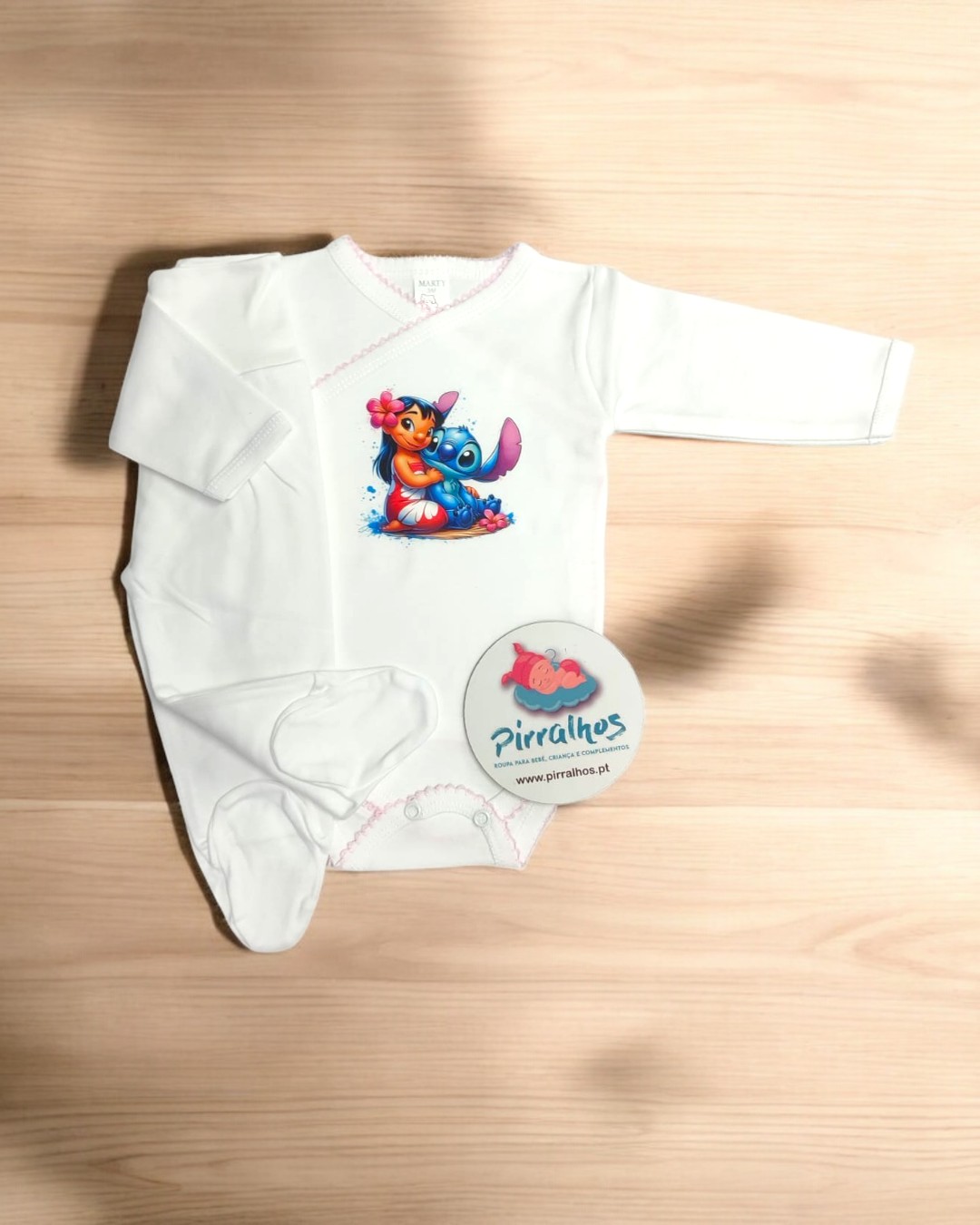 Body branco de bebé com personagens animados e etiqueta redonda com texto